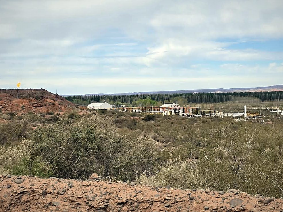 Locación remota con antorcha y cerros en Vaca Muerta